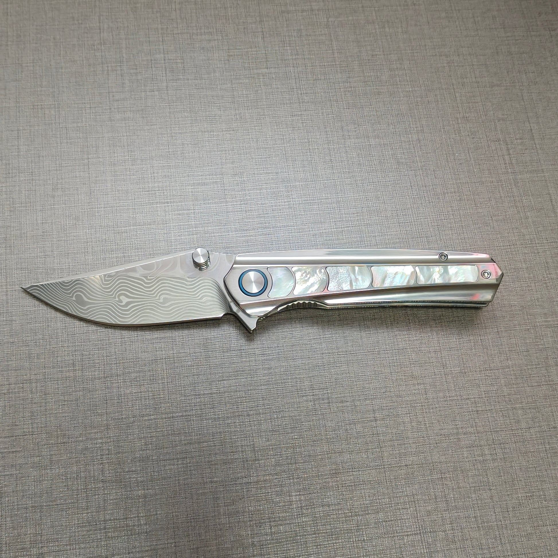 VORIXN Ocean Mirage folding knife open, non-clip side, Damascus blade in horizontal position