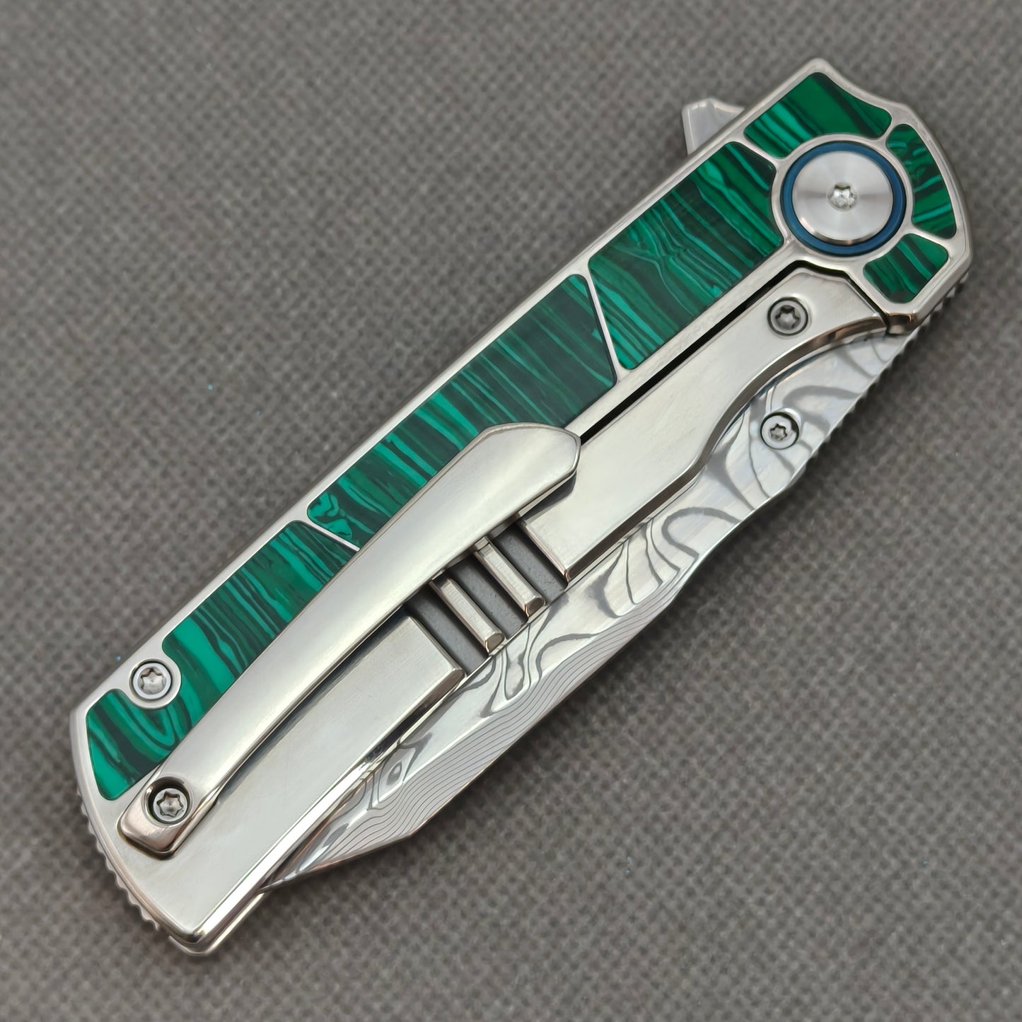 VORIXN KB062 closed clip-side view with pocket clip, screws, and malachite inlaid titanium handle back.