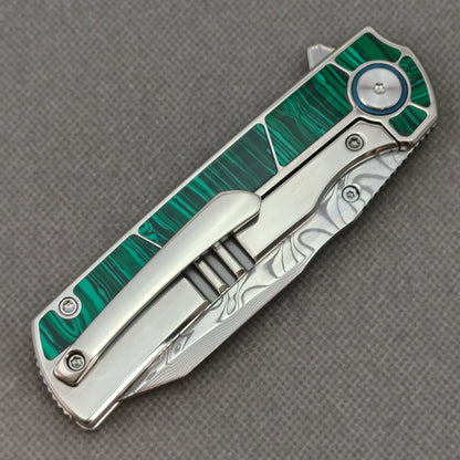 VORIXN KB062 closed clip-side view with pocket clip, screws, and malachite inlaid titanium handle back.