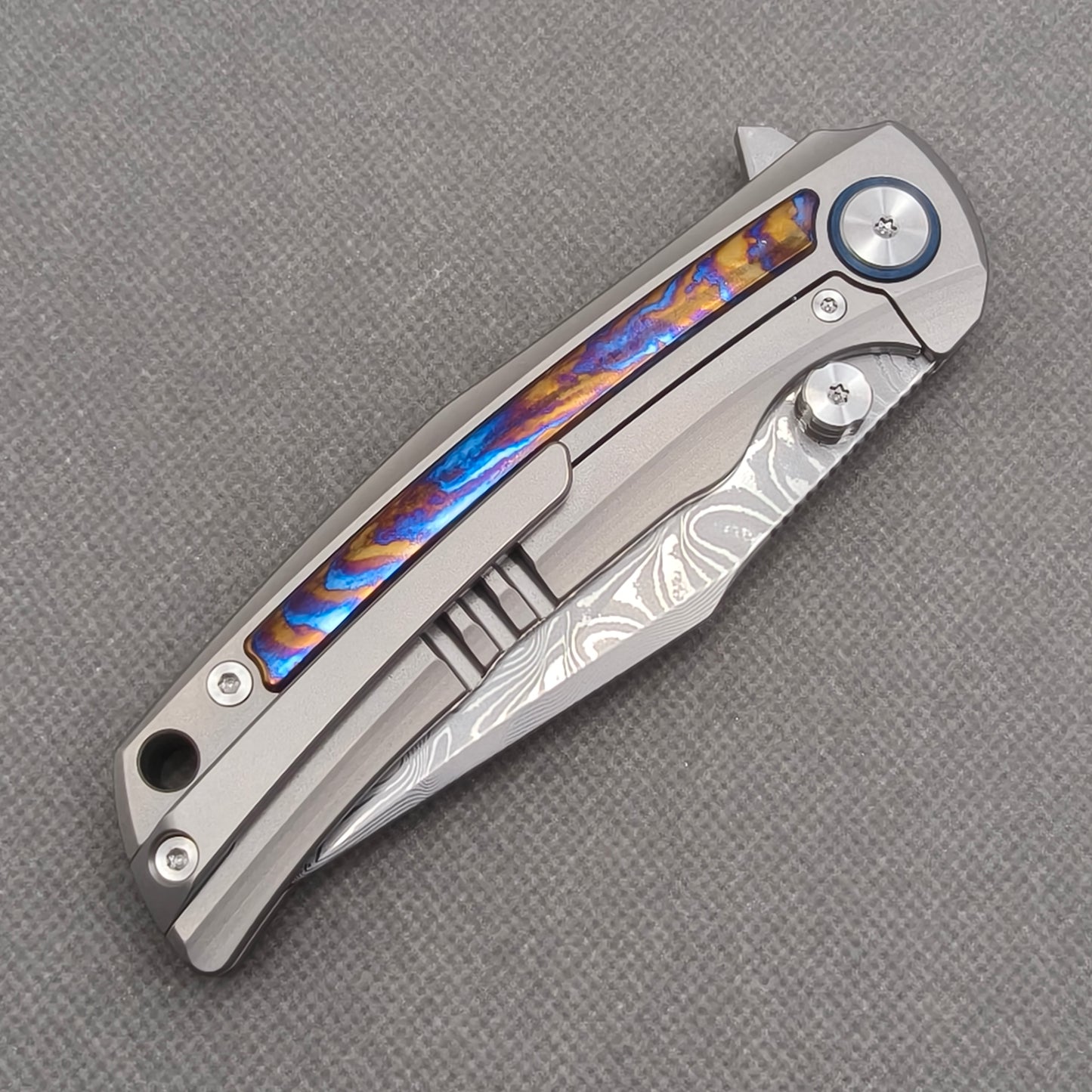 VORIXN KB019 closed clip-side view with pocket clip, screws, and zirconium inlay handle back.
