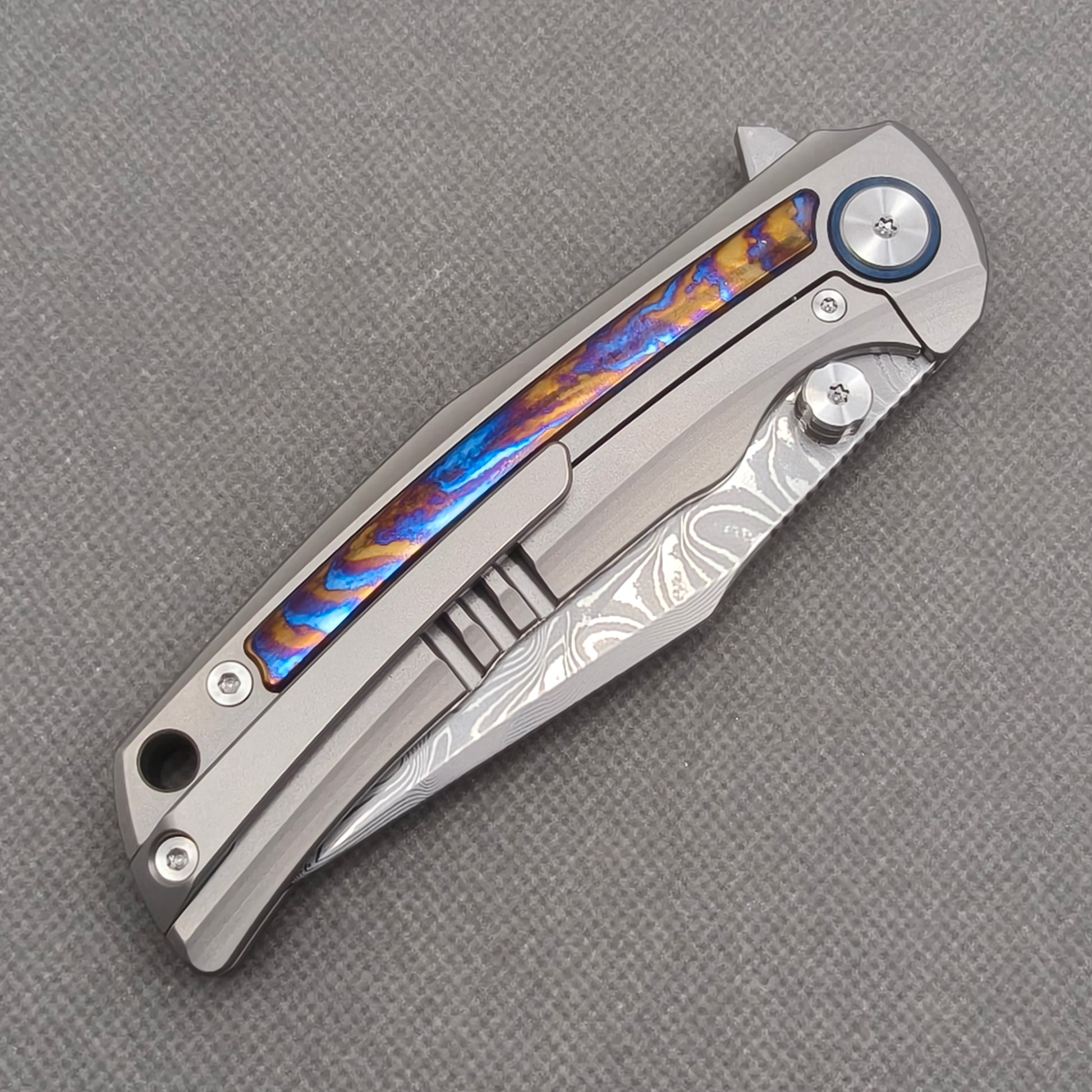 VORIXN KB019 closed clip-side view with pocket clip, screws, and zirconium inlay handle back.