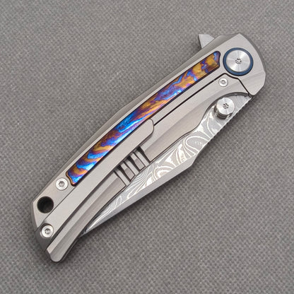 VORIXN KB019 closed clip-side view with pocket clip, screws, and zirconium inlay handle back.