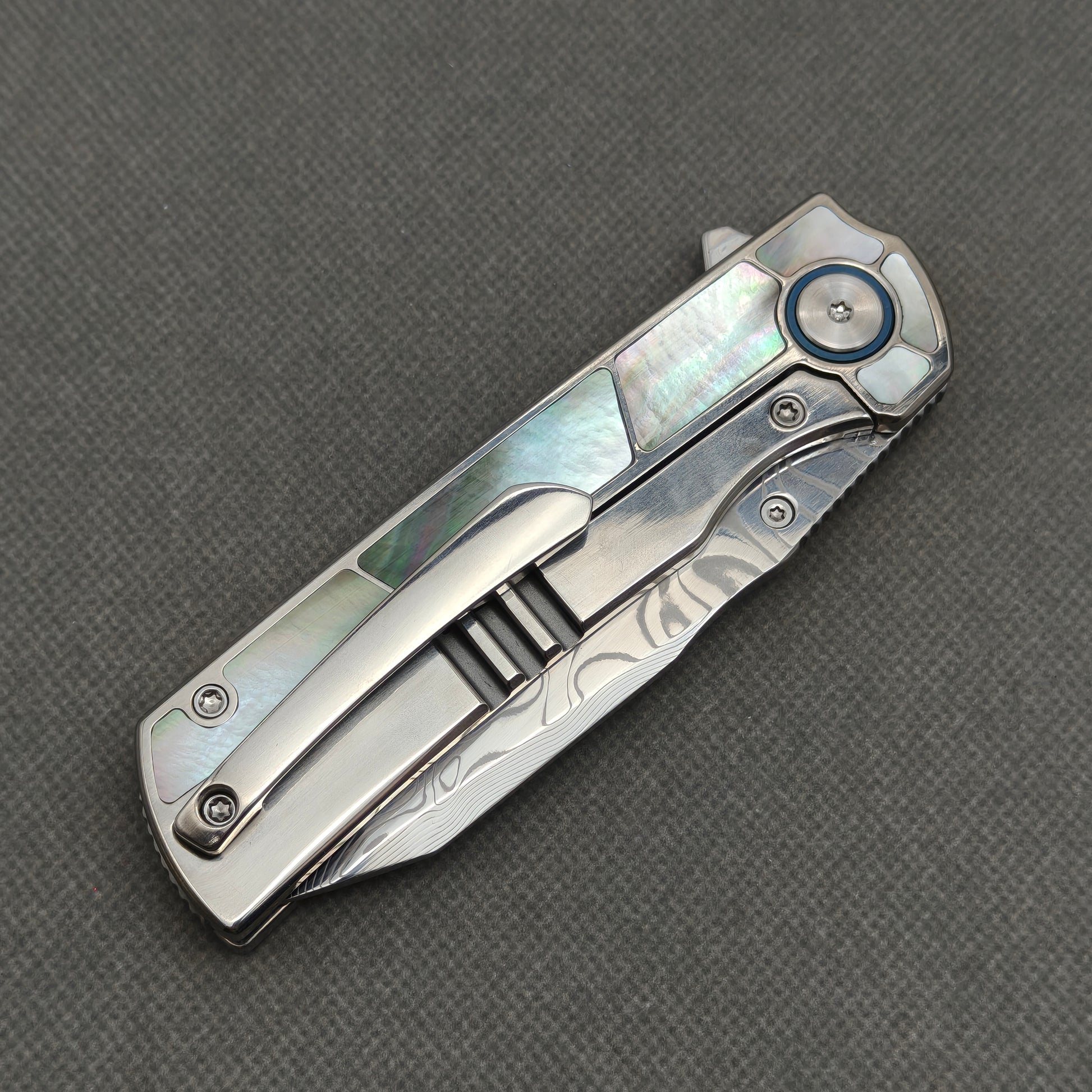 VORIXN KB059 closed clip-side view with pocket clip, screws, and black pearl inlaid titanium handle back.