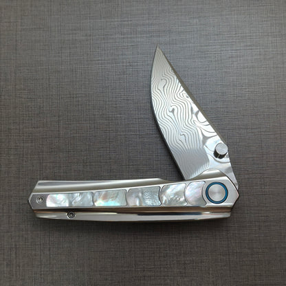 VORIXN Ocean Mirage folding knife half open, non-clip side, titanium handle shown horizontally