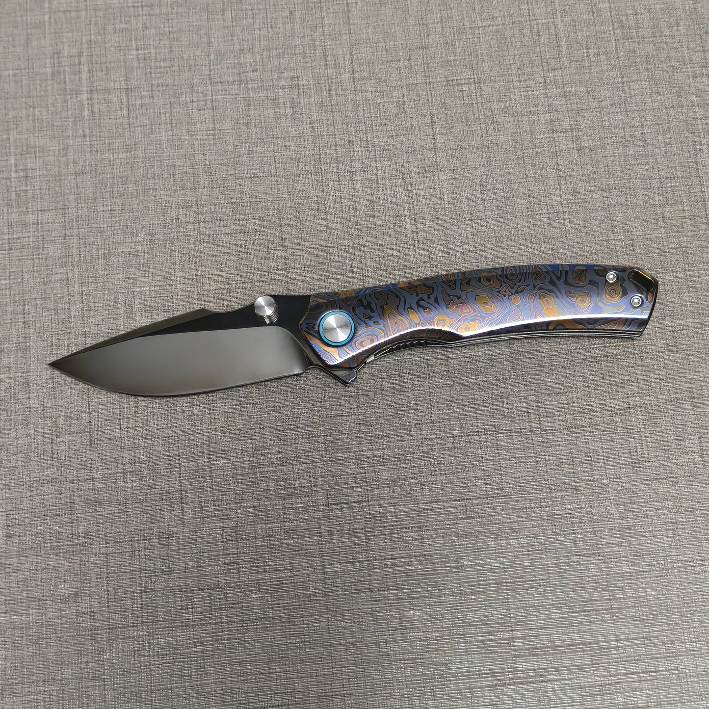 VORIXN Topograph folding knife open with blade horizontal, showcasing zirconium handle details