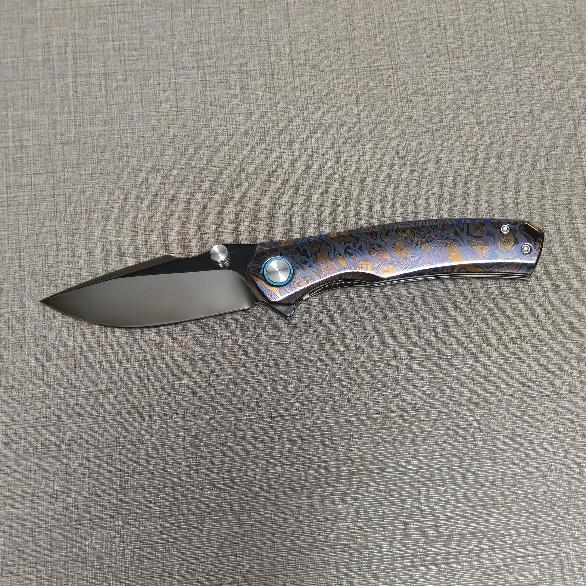 VORIXN Topograph folding knife open with blade horizontal, showcasing zirconium handle details