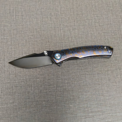 VORIXN Topograph folding knife open with blade horizontal, showcasing zirconium handle details