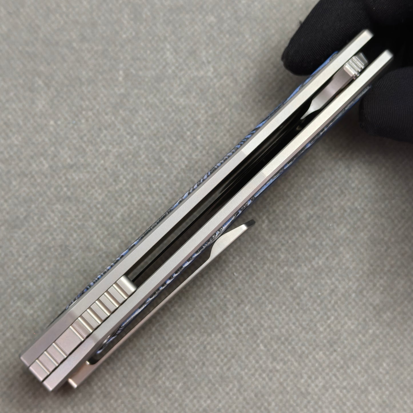 VORIXN Carbon Crest KB003 Folding Knife – closed side construction view showing pocket clip, spacer, and handle layers