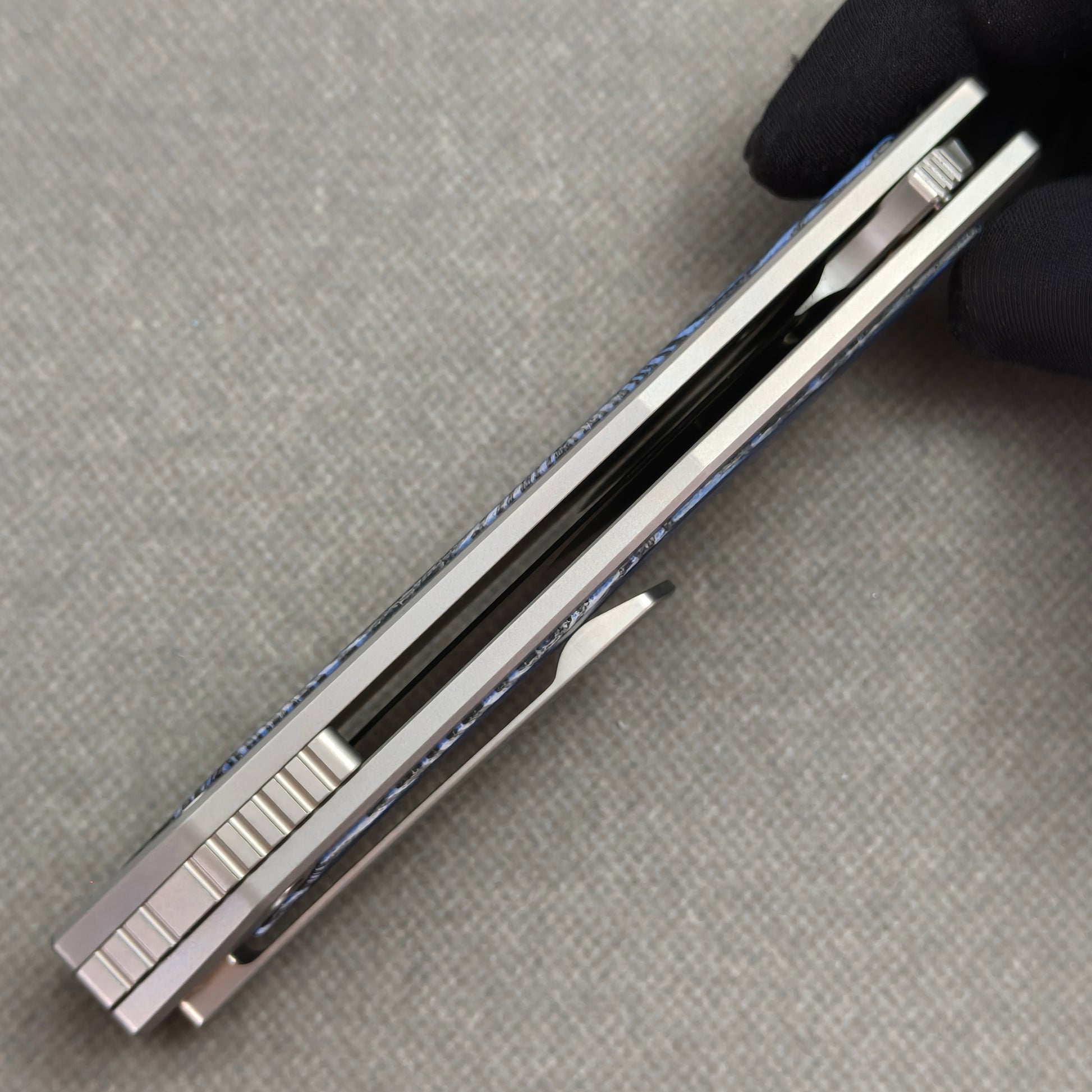 VORIXN Carbon Crest KB003 Folding Knife – closed side construction view showing pocket clip, spacer, and handle layers