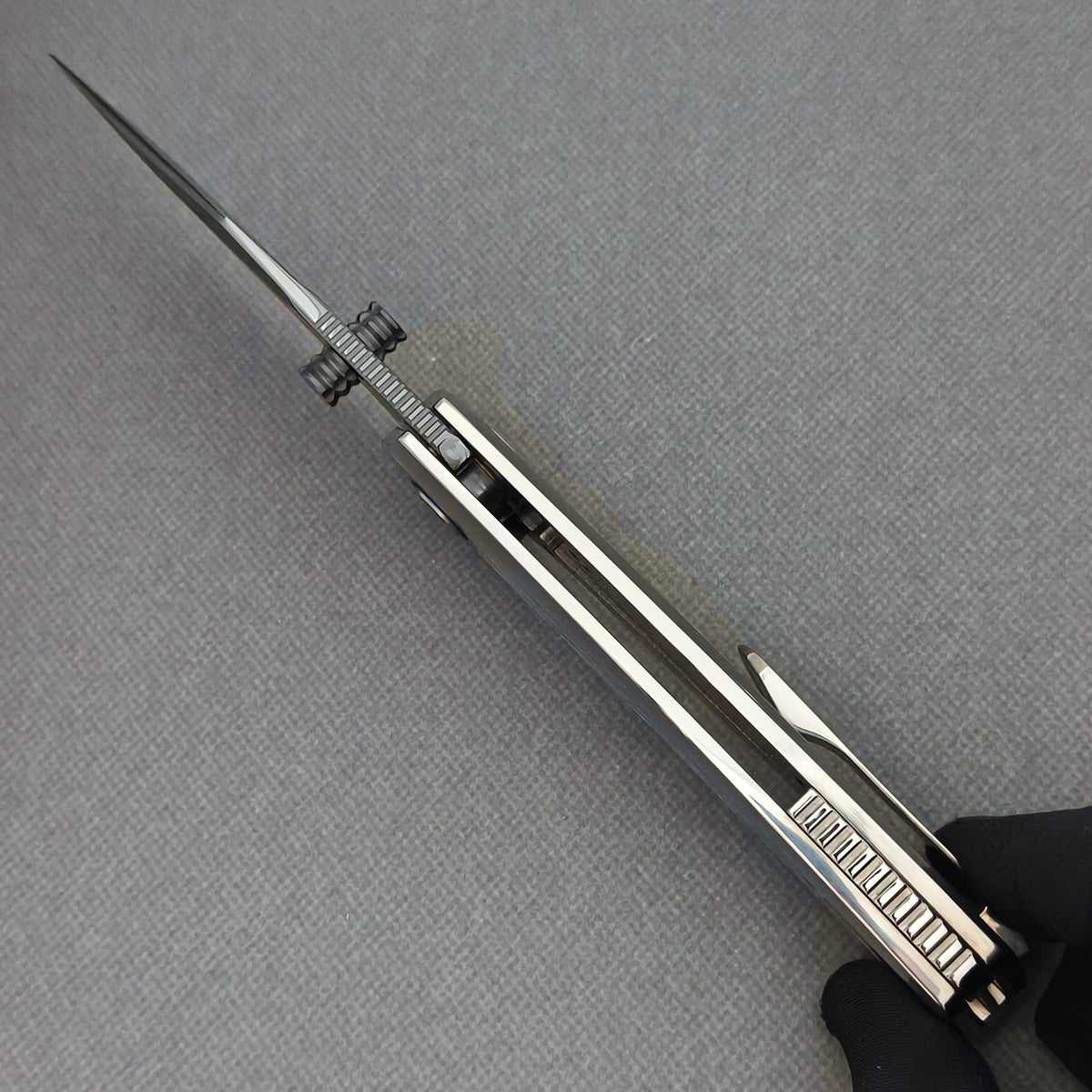 Spine view of the open VORIXN Ocean Mirage KB093 showing blade jimping, dual thumb studs and handle construction.