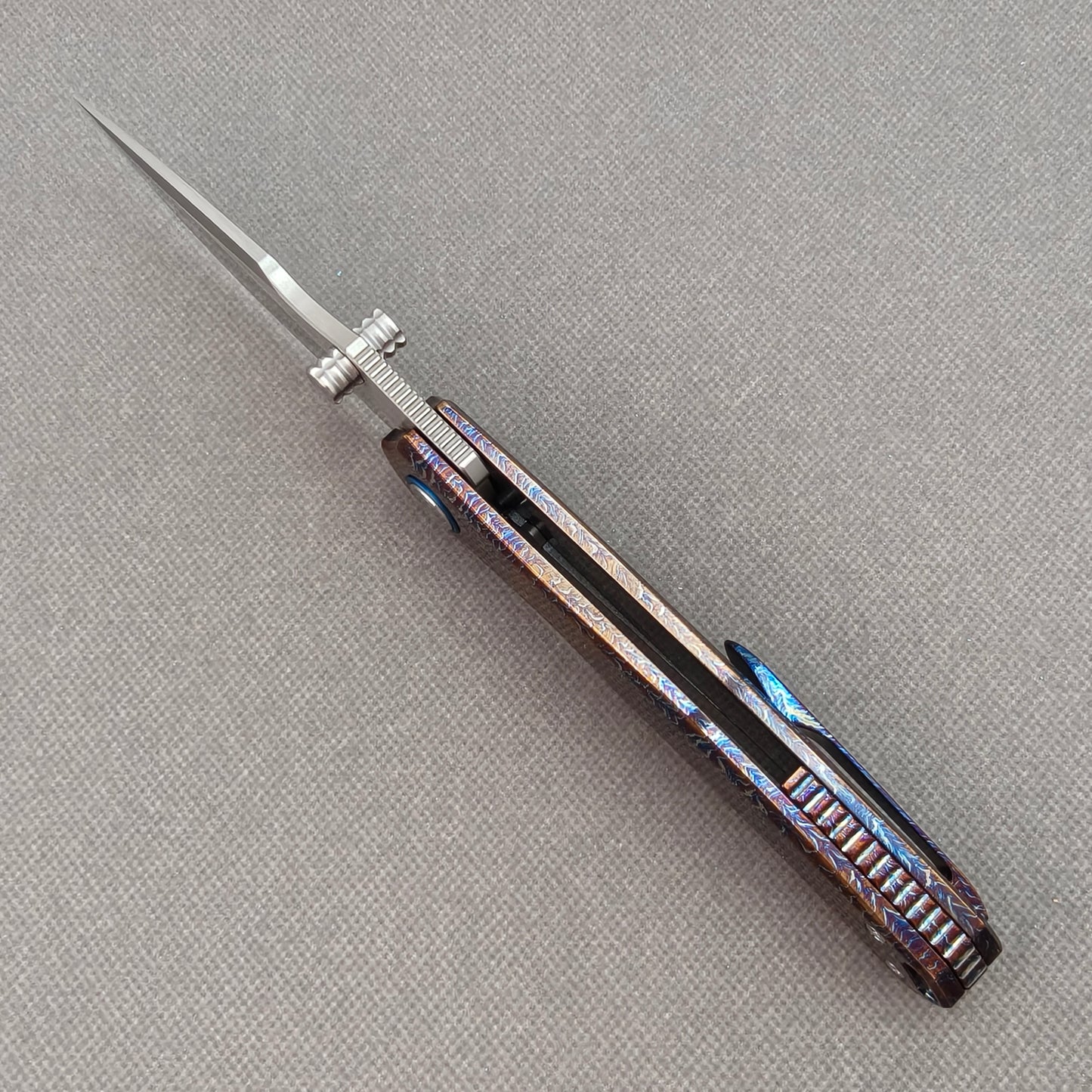 VORIXN KB051 open spine-side structure showing blade alignment and hand-flamed titanium handle thickness.