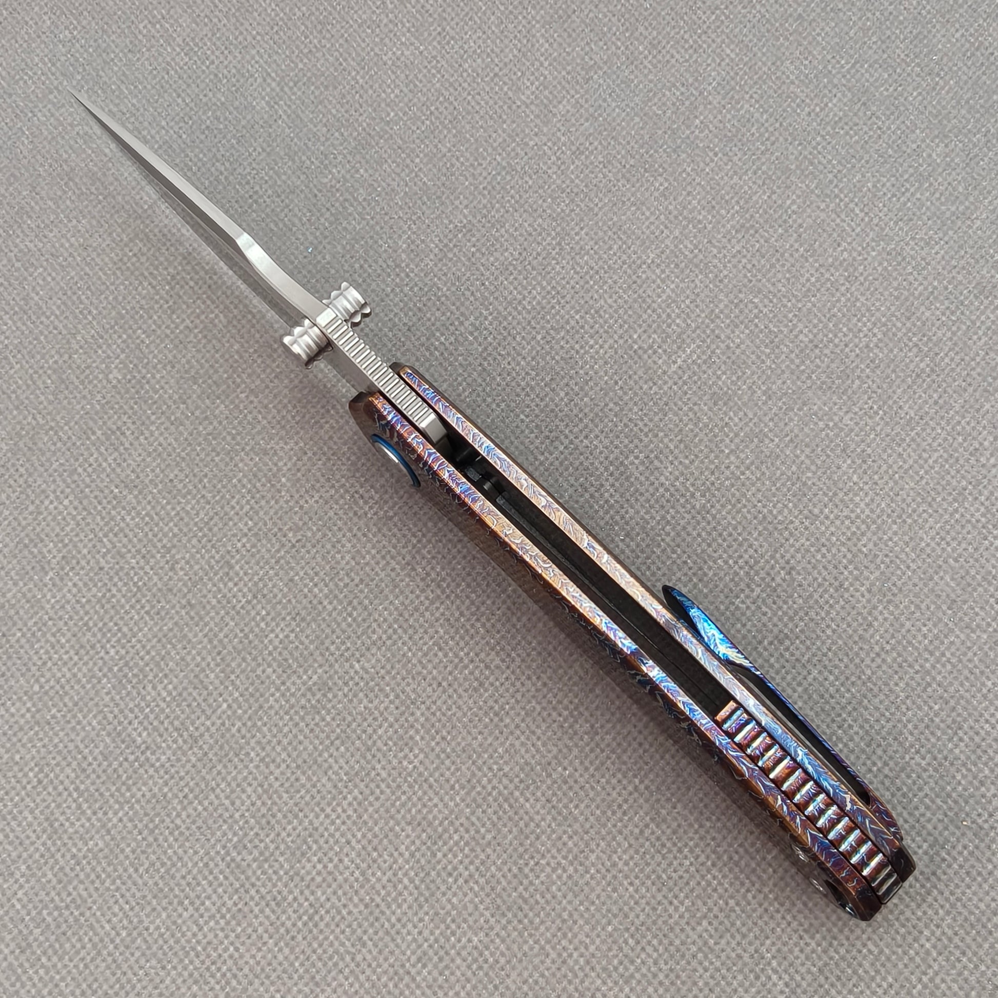 VORIXN KB051 open spine-side structure showing blade alignment and hand-flamed titanium handle thickness.