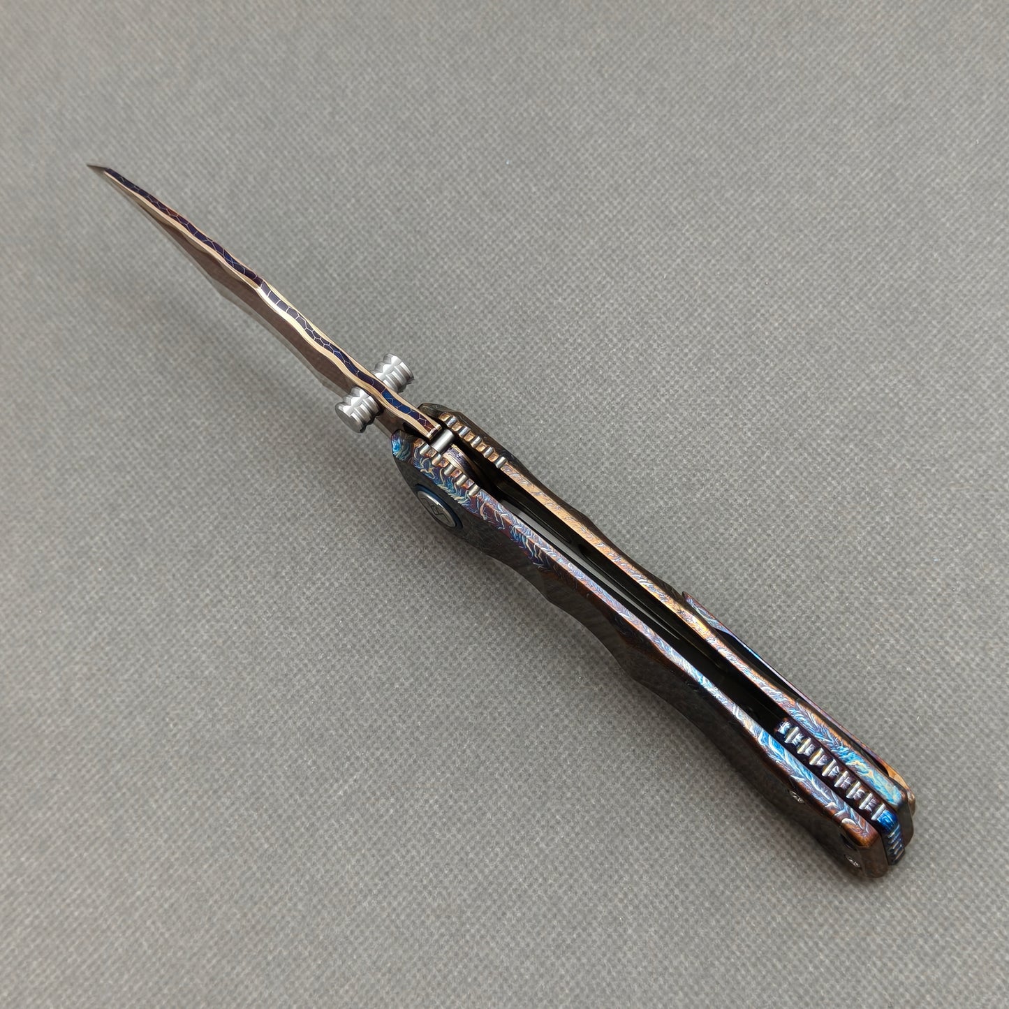 VORIXN KB057 open spine-side structure showing blade alignment and hand-flamed titanium handle thickness.