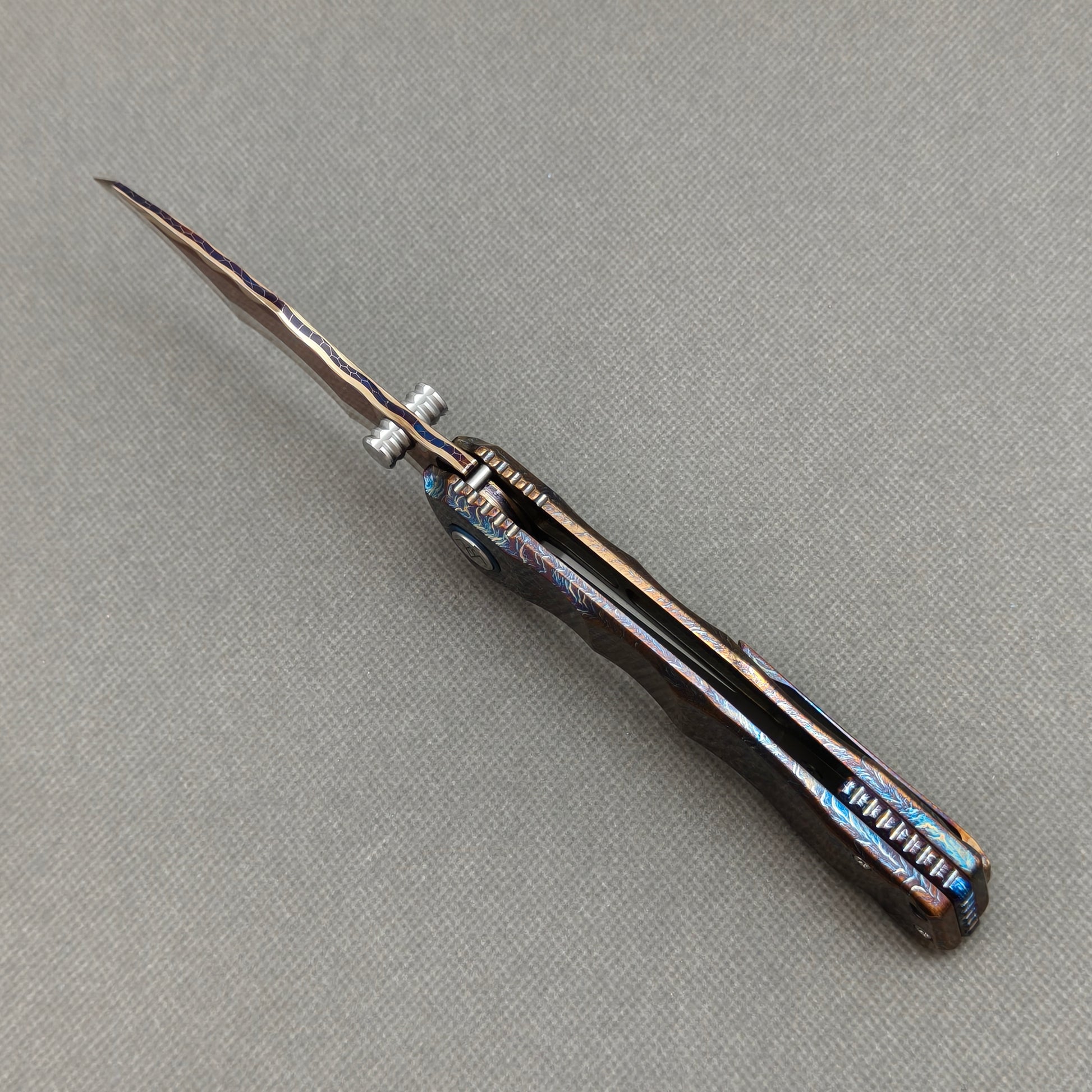 VORIXN KB057 open spine-side structure showing blade alignment and hand-flamed titanium handle thickness.