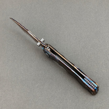 VORIXN KB057 open spine-side structure showing blade alignment and hand-flamed titanium handle thickness.