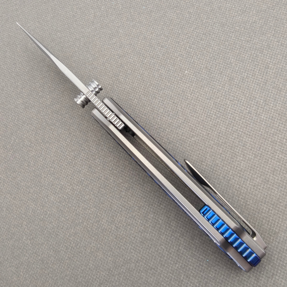 VORIXN Tidecipher KB157 Folding Knife – open spine view showing blade alignment, thumb studs, and blue backspacer.
