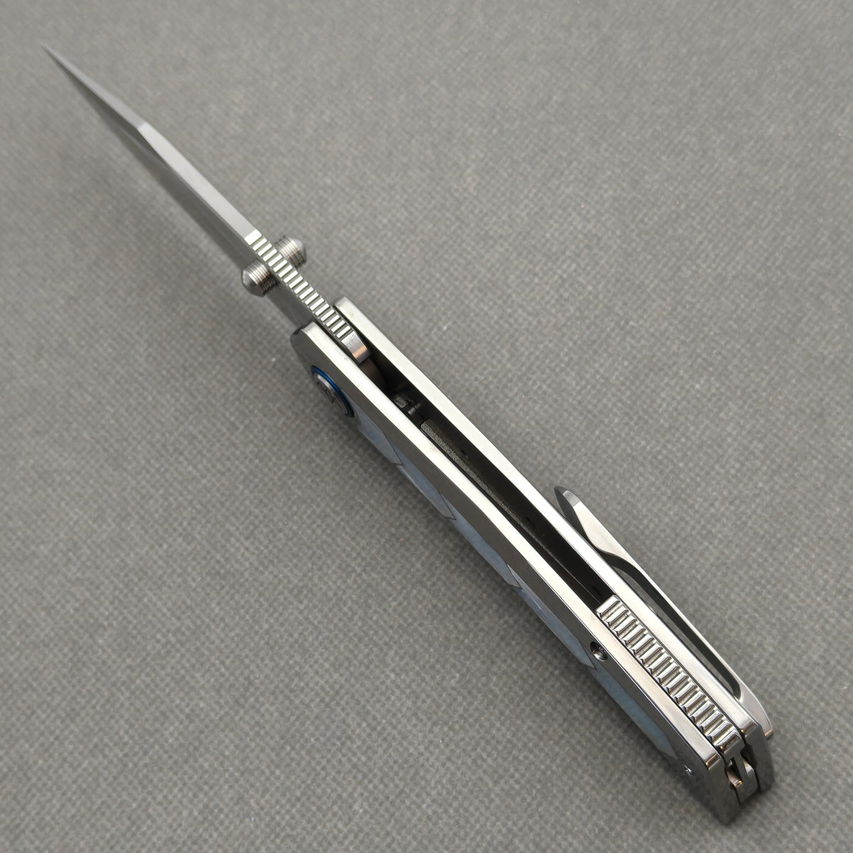 Spine view of the open VORIXN Pearlglint KB159 showing blade jimping, dual thumb studs and handle construction.