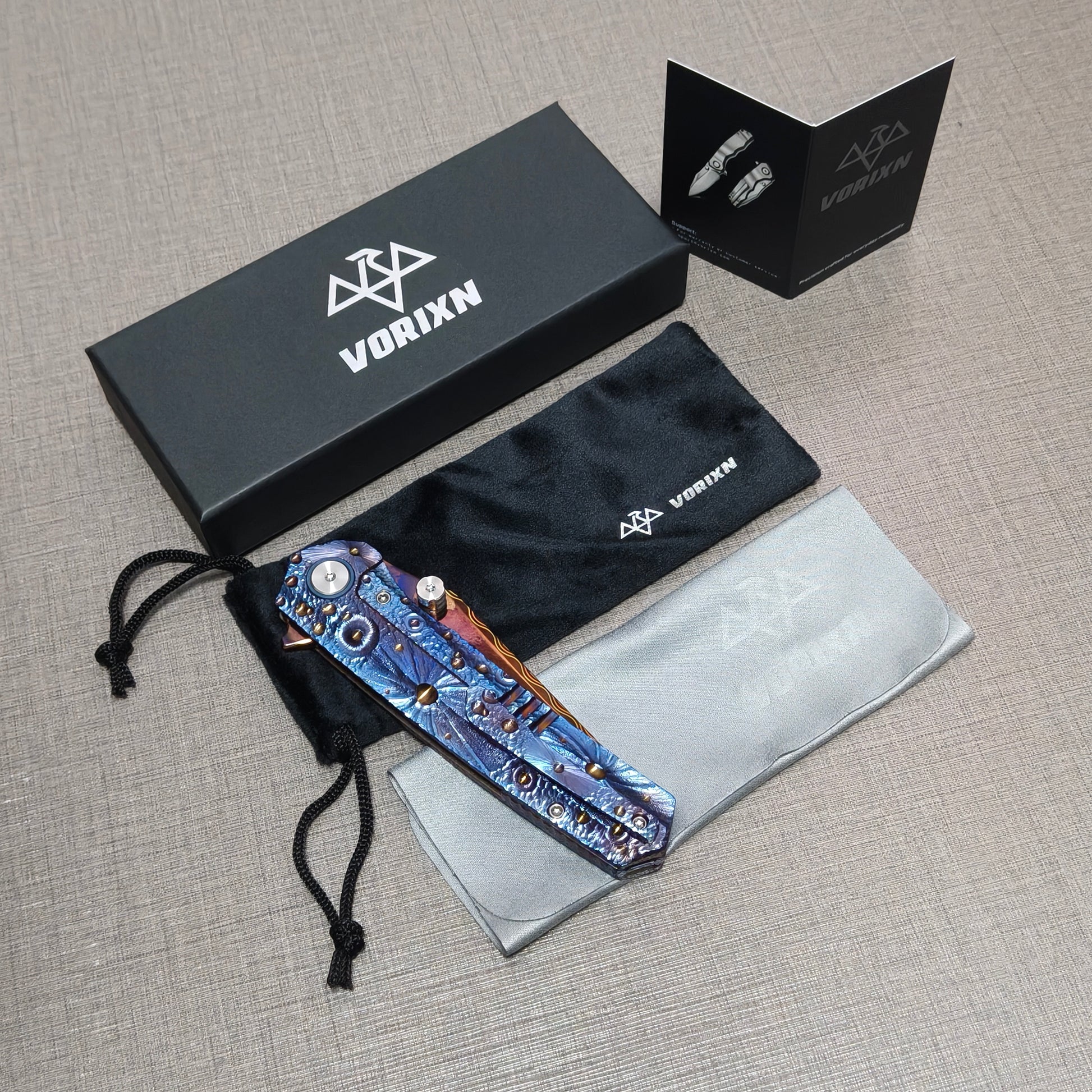 VORIXN folding knife packaging including a soft drawstring pouch, care and use instruction card, and microfiber cleaning cloth