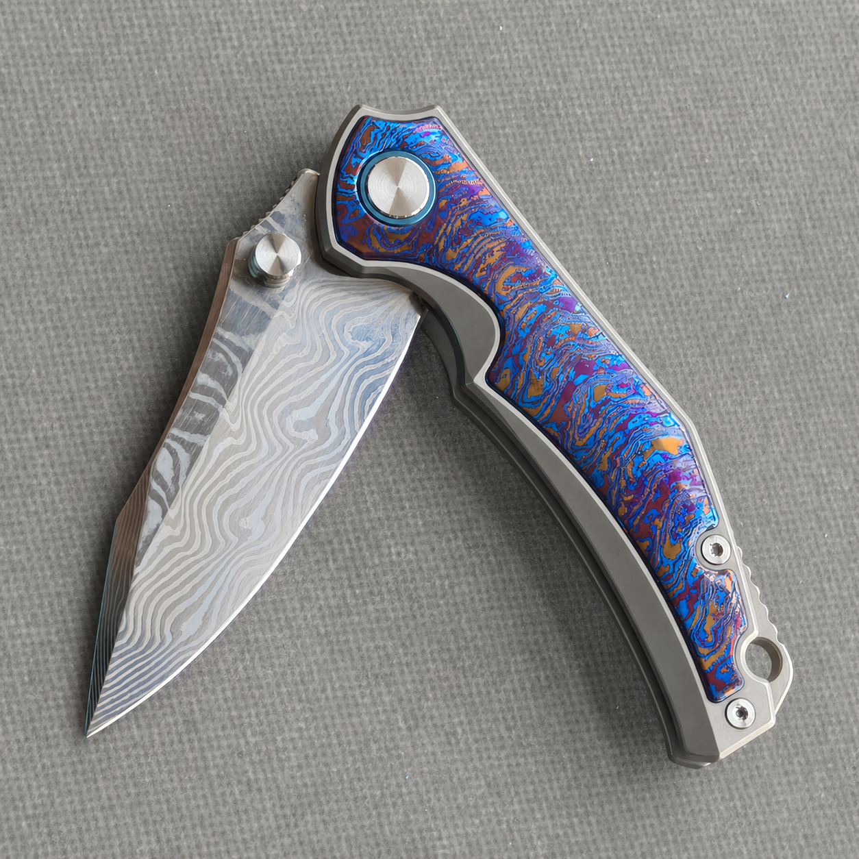 VORIXN KB031 partially open EDC folding knife showing flipper, thumb stud, pivot, and zirconium inlay handle profile.