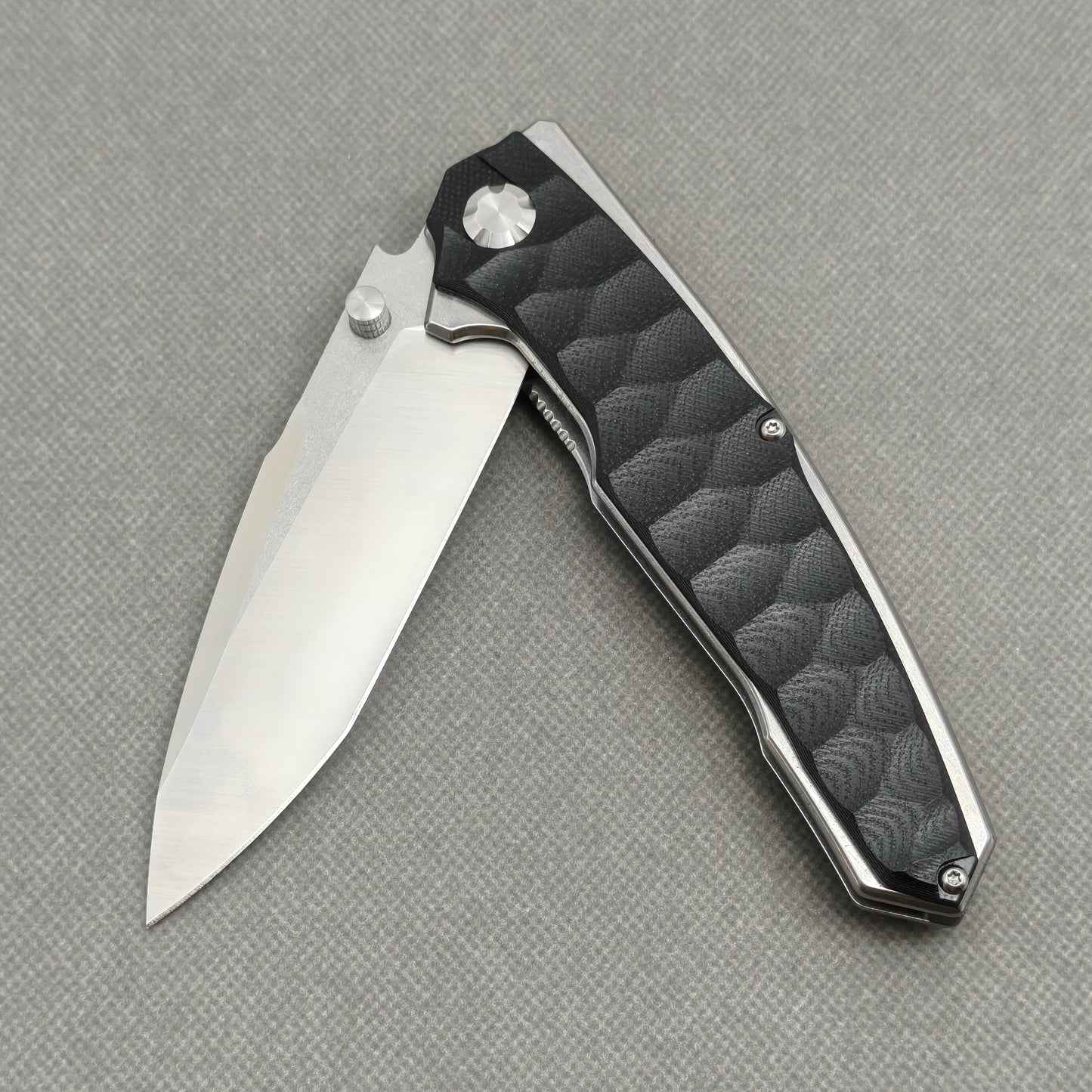 VORIXN KA009 partially open EDC folding knife showing flipper, thumb stud, pivot, and handle profile.