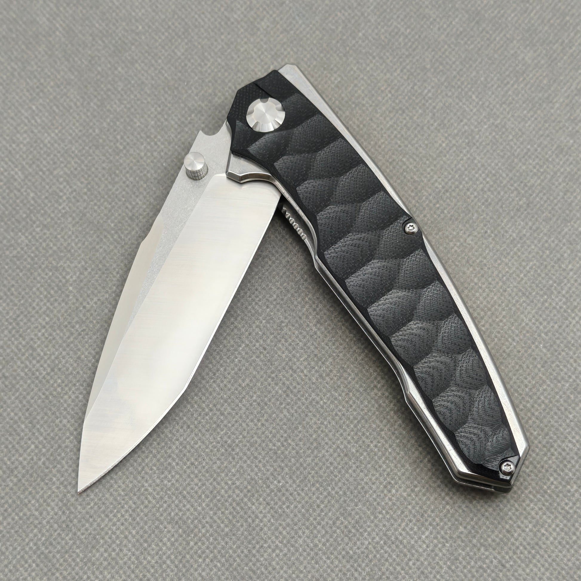 VORIXN KA009 partially open EDC folding knife showing flipper, thumb stud, pivot, and handle profile.