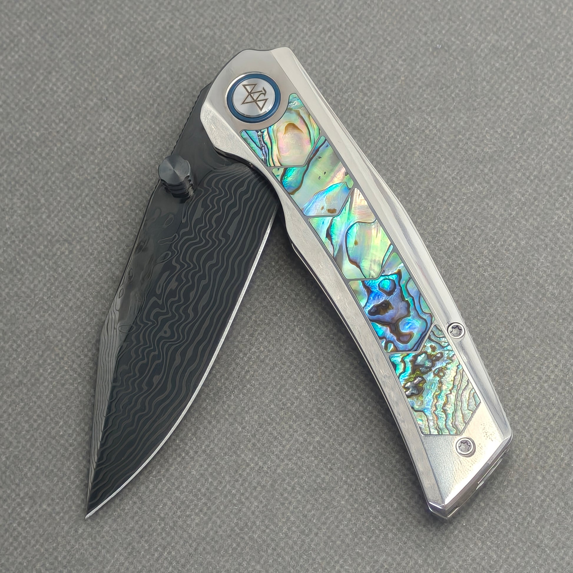 VORIXN Ocean Mirage KB130 Folding Knife – partially open EDC view showing flipper, thumb stud, pivot, and deep-sea abalone shell inlay titanium handle profile