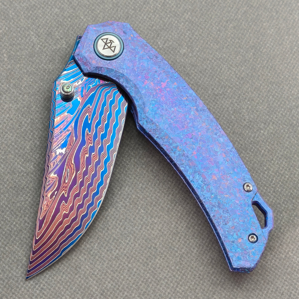 VORIXN Rimeflare KB132 Folding Knife – partially open EDC view showing flipper, thumb stud, pivot, and Crystallized Titanium handle profile.