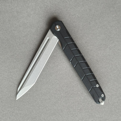 VORIXN KM001 partially open folding knife showing flipper, pivot, and carbon fiber handle profile.