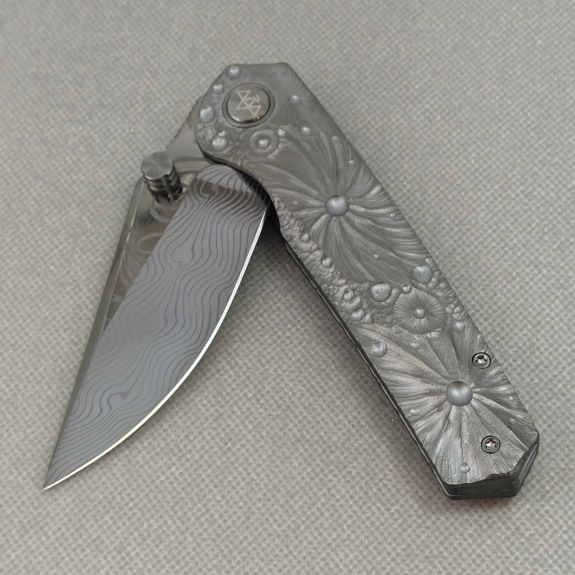 VORIXN KB098 Impact Origin Folding Knife – partially open EDC view showing flipper, thumb stud, pivot, and engraved Titanium handle profile
