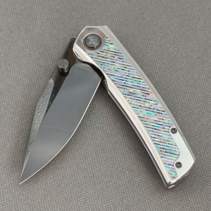 VORIXN KB103 Ocean Mirage Folding Knife – partially open EDC view showing flipper, thumb stud, pivot, and Iridescent Mother-of-Pearl Inlaid Titanium handle profile