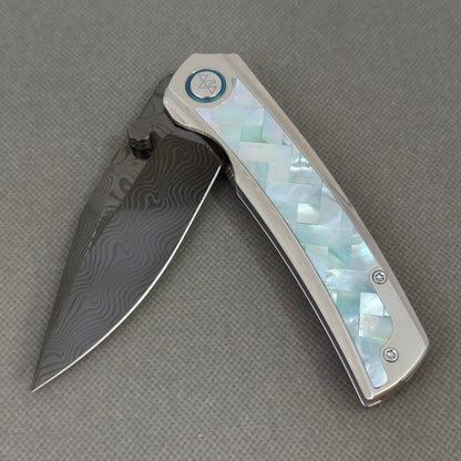 VORIXN KB104 Ocean Mirage Folding Knife – partially open EDC view showing flipper, thumb stud, pivot, and Mother-of-Pearl Inlaid Titanium handle profile