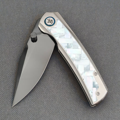 VORIXN Ocean Mirage KB093 with the blade partially open, showing the white patterned handle inlay and black thumb stud.