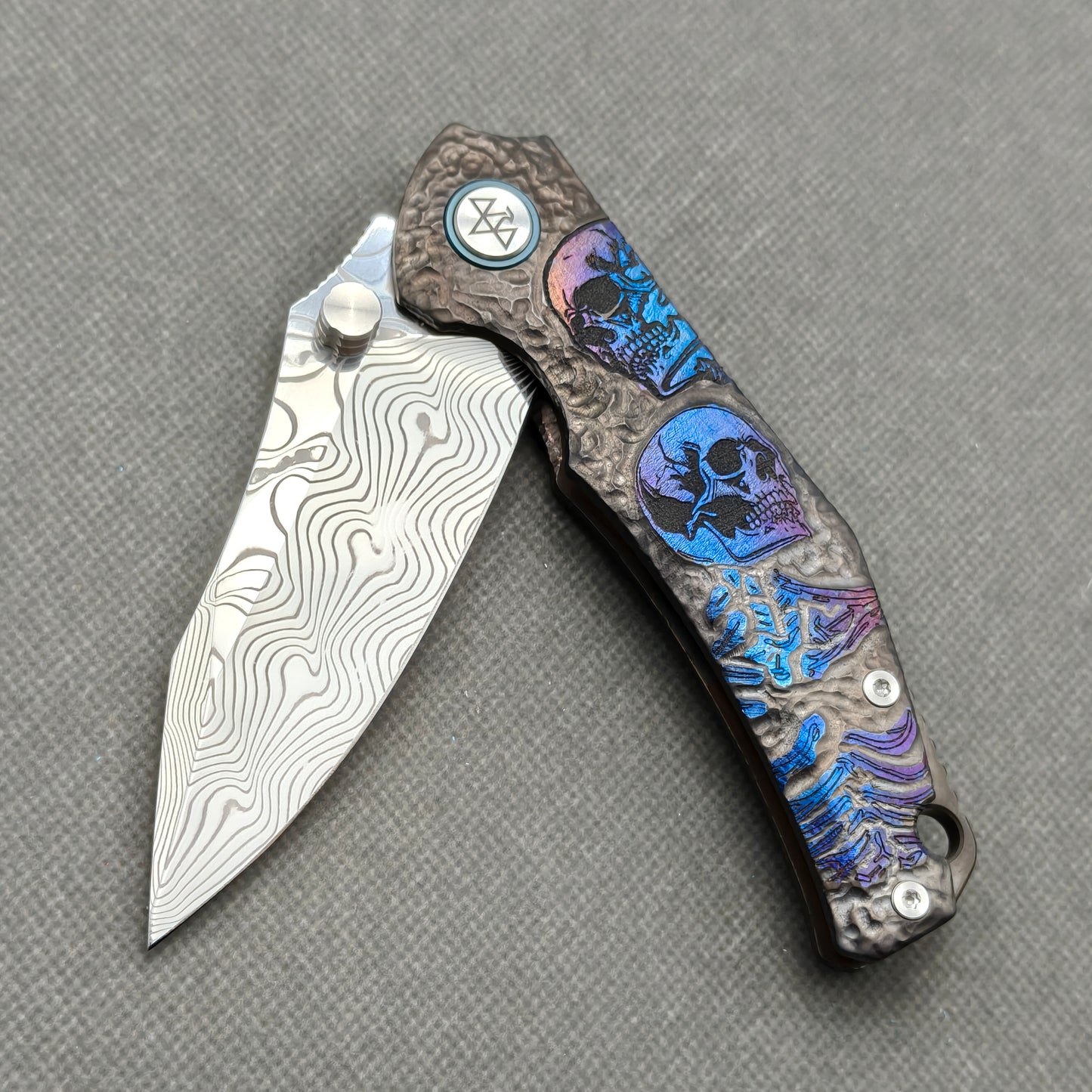 VORIXN KB096 partially open EDC folding knife showing flipper, thumb stud, pivot, and engraved handle profile.