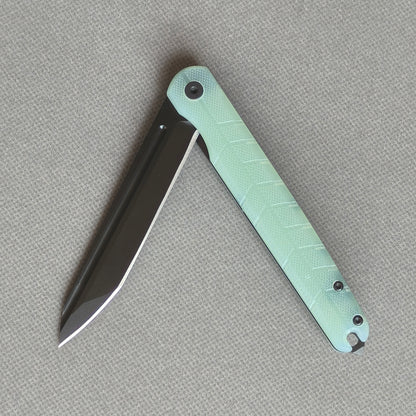 VORIXN KM004 partially open folding knife showing flipper, pivot, and carbon fiber handle profile.