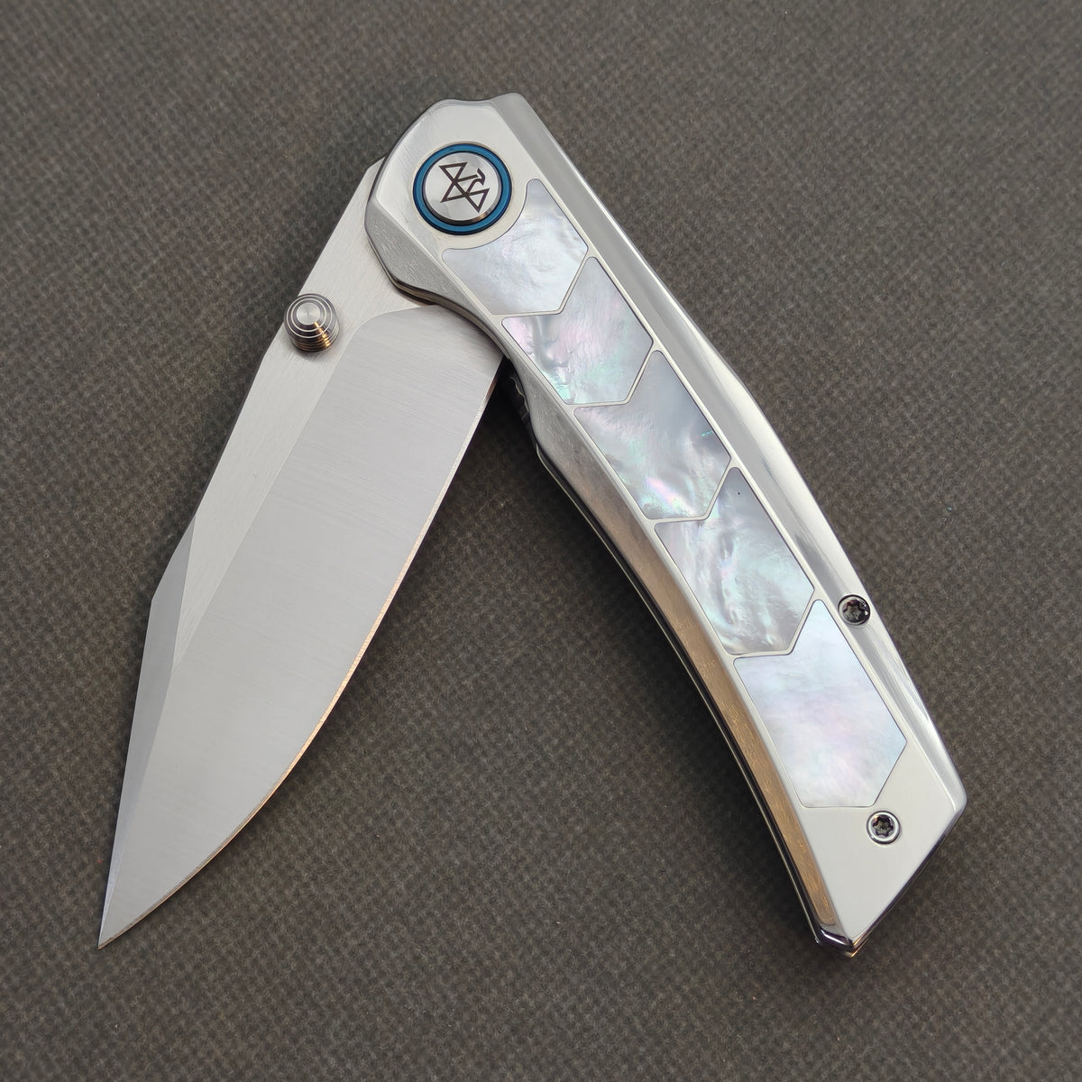 VORIXN Pearlglint KB159 with the blade partially open, showing white geometric handle inlays and a blue pivot ring.
