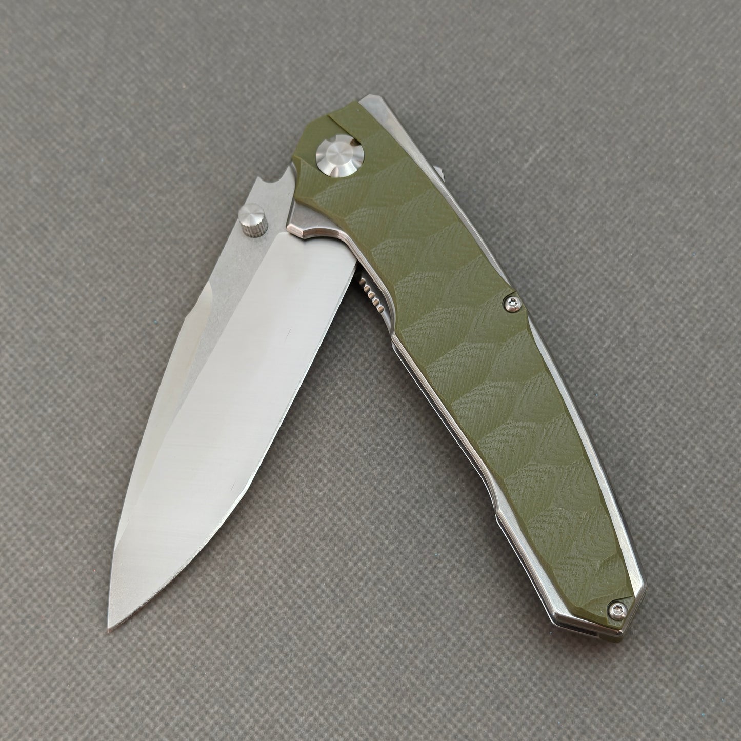 VORIXN KA007 partially open EDC folding knife showing flipper, thumb stud, pivot, and G10 handle profile.