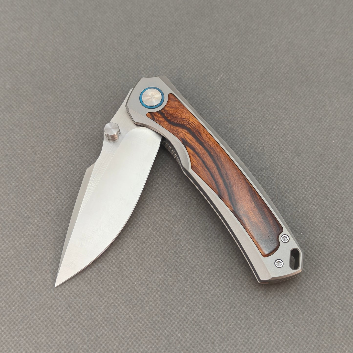 VORIXN KB040 partially open EDC folding knife showing flipper, thumb stud, pivot, and ironwood handle profile.