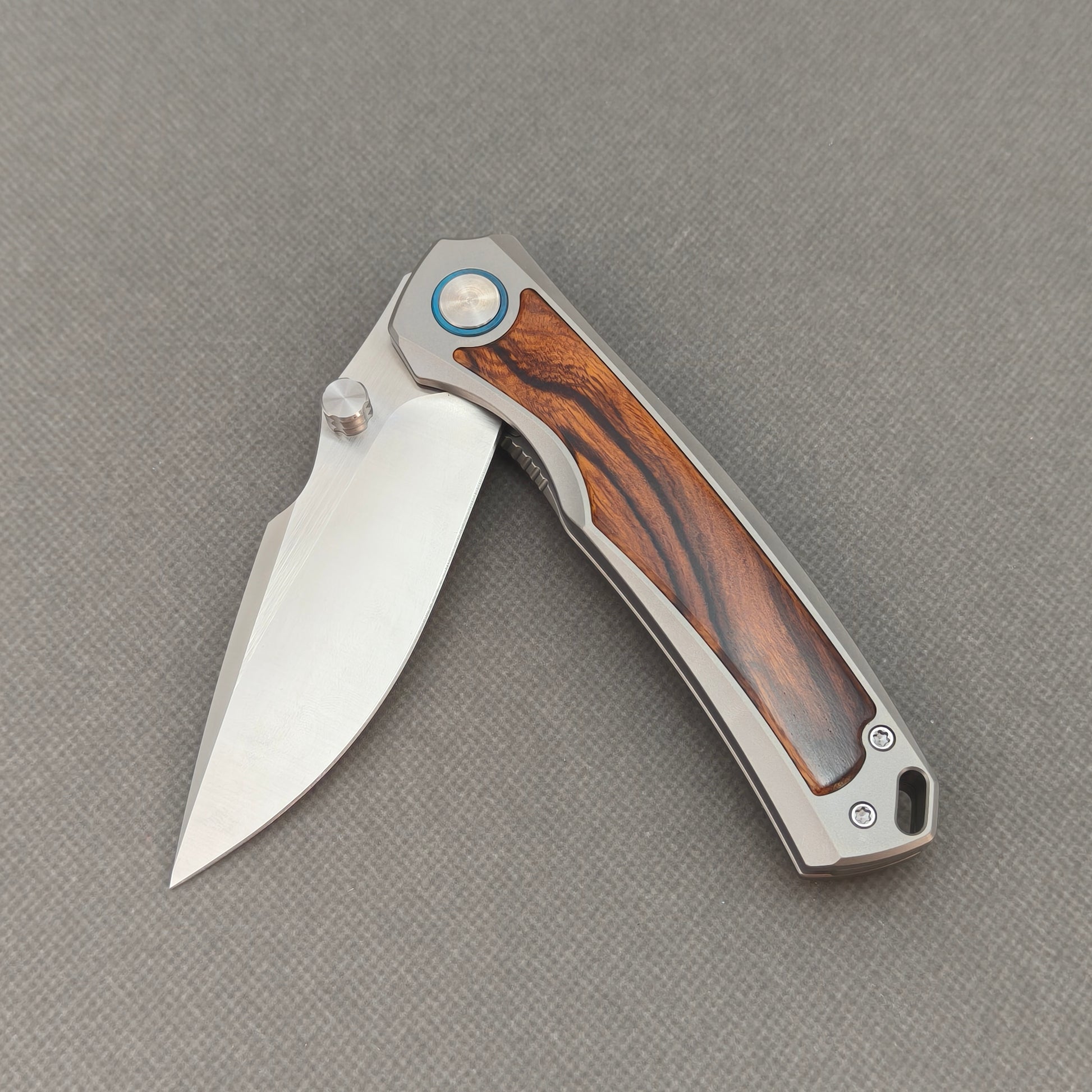VORIXN KB040 partially open EDC folding knife showing flipper, thumb stud, pivot, and ironwood handle profile.