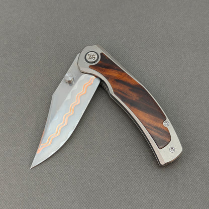 VORIXN KB074 partially open EDC folding knife showing flipper, thumb stud, pivot, and ironwood handle profile.