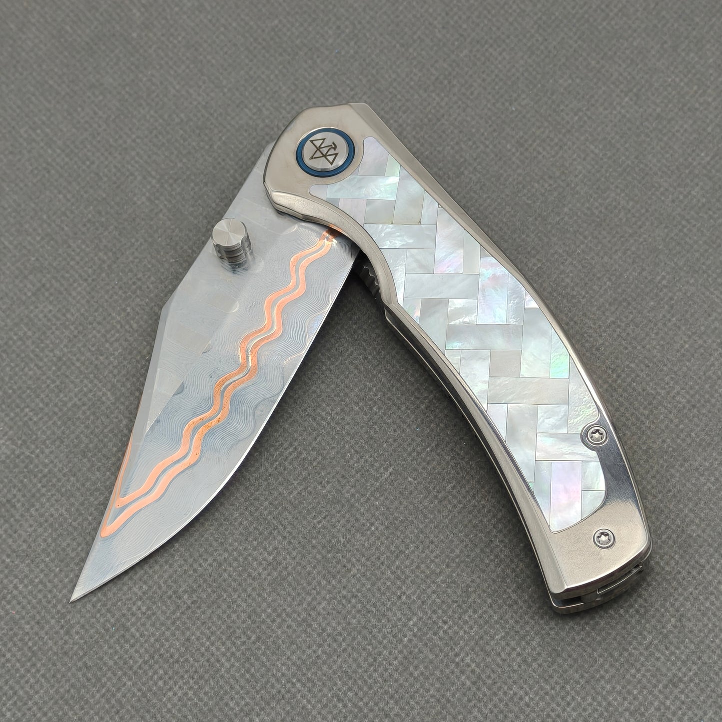 VORIXN KB068 partially open EDC folding knife showing flipper, thumb stud, pivot, and white pearl inlaid handle profile.