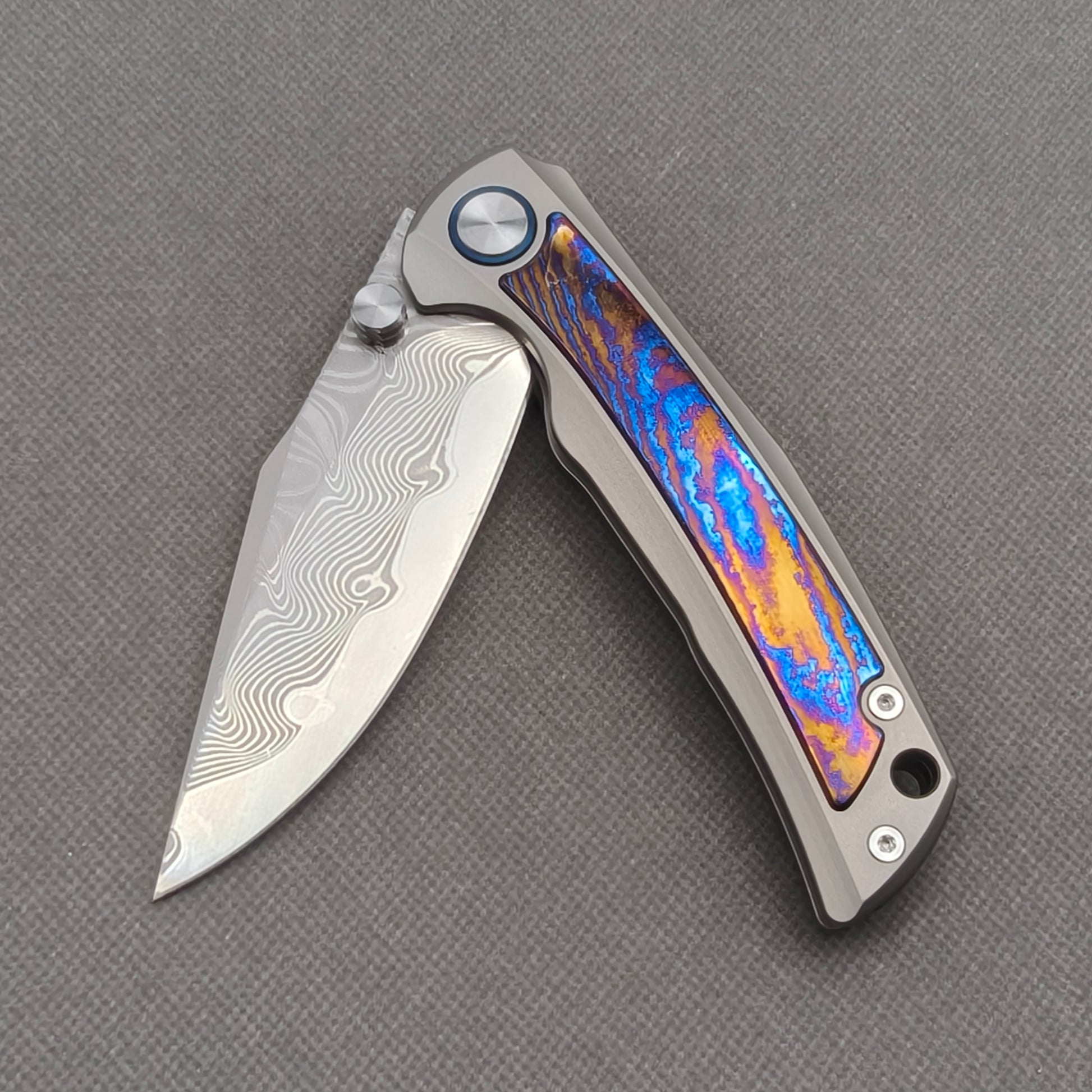 VORIXN KB019 partially open EDC folding knife showing flipper, thumb stud, pivot, and zirconium inlay handle profile.