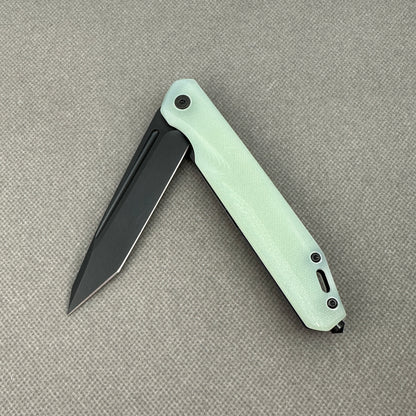 VORIXN KM005 partially open folding knife showing flipper, pivot, and carbon fiber handle profile.