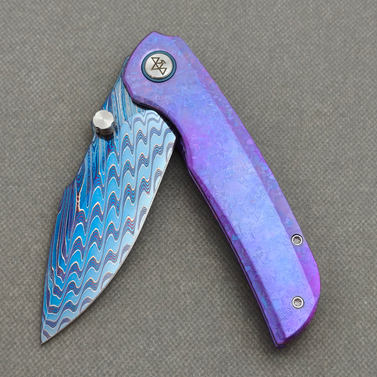 VORIXN Rimeforge KB125 Folding Knife – partially open EDC view showing flipper, thumb stud, pivot, and crystallized titanium handle profile.