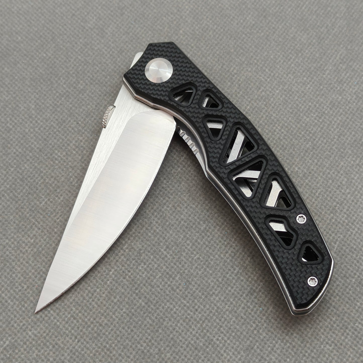 VORIXN KA003 partially open EDC folding knife showing flipper, thumb stud, pivot, and G10 handle profile.