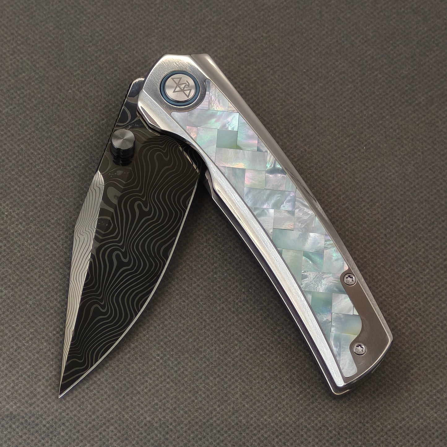 VORIXN Ocean Mirage KB104 Folding Knife – partially open EDC view showing flipper, thumb stud, pivot, and White Mother-of-Pearl Inlaid Titanium handle profile