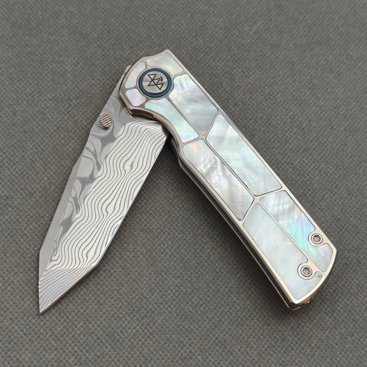 VORIXN KB063 partially open EDC folding knife showing flipper, thumb stud, pivot, and white pearl inlaid handle profile.