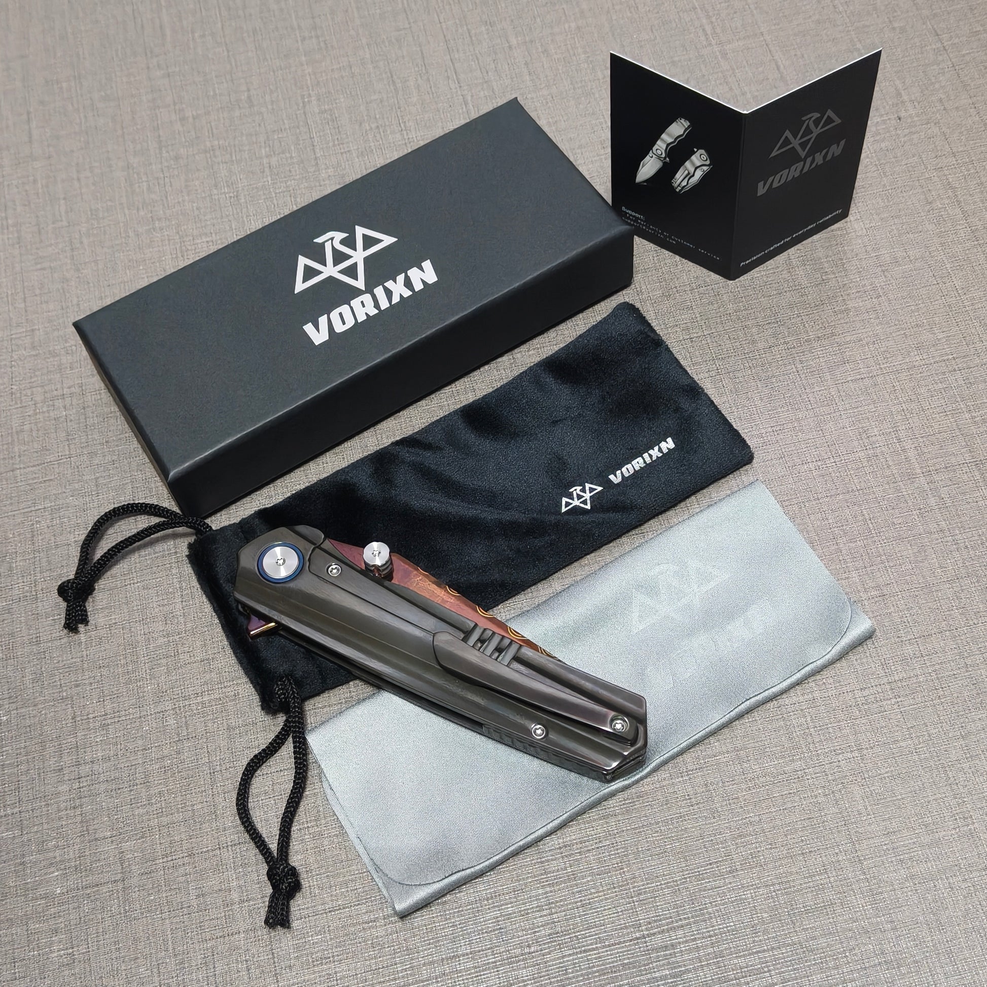 VORIXN folding knife packaging contents including a soft drawstring pouch, a care and usage instruction card, and a microfiber cleaning cloth