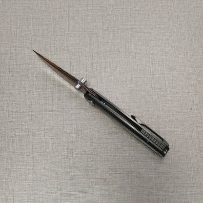 Open VORIXN Pyretic folding knife viewed from the spine, highlighting the centered Damascus blade and the balanced zirconium handle design