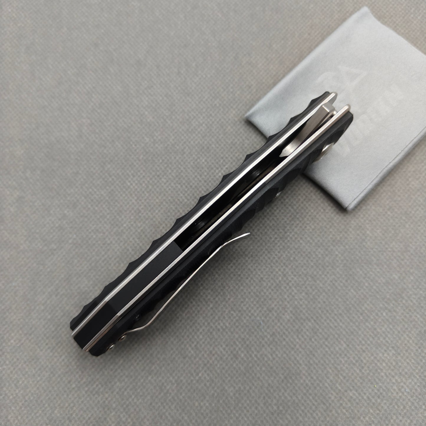 VORIXN KA008 partially open EDC folding knife showing flipper, thumb stud, pivot, and G10 handle profile.