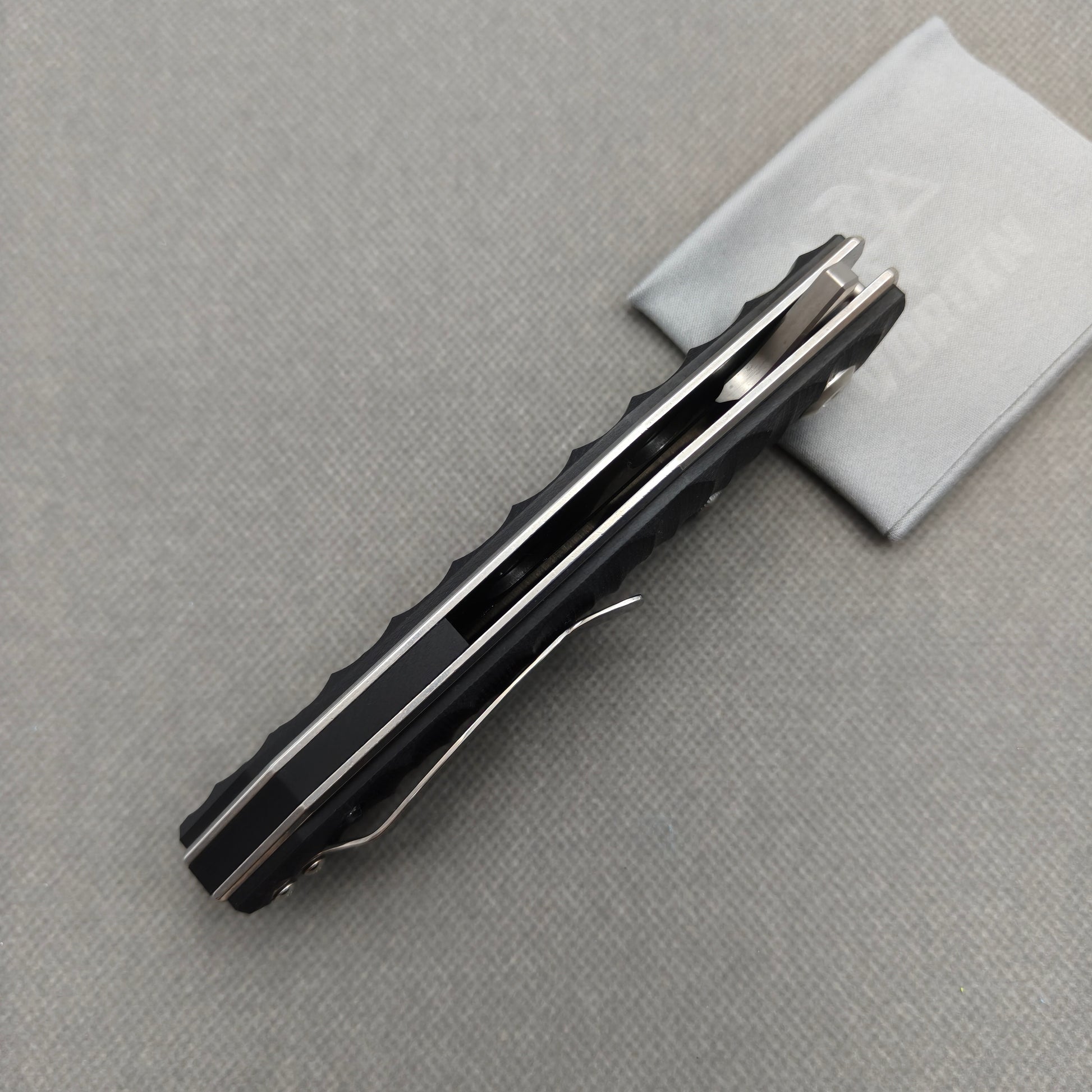 VORIXN KA008 partially open EDC folding knife showing flipper, thumb stud, pivot, and G10 handle profile.